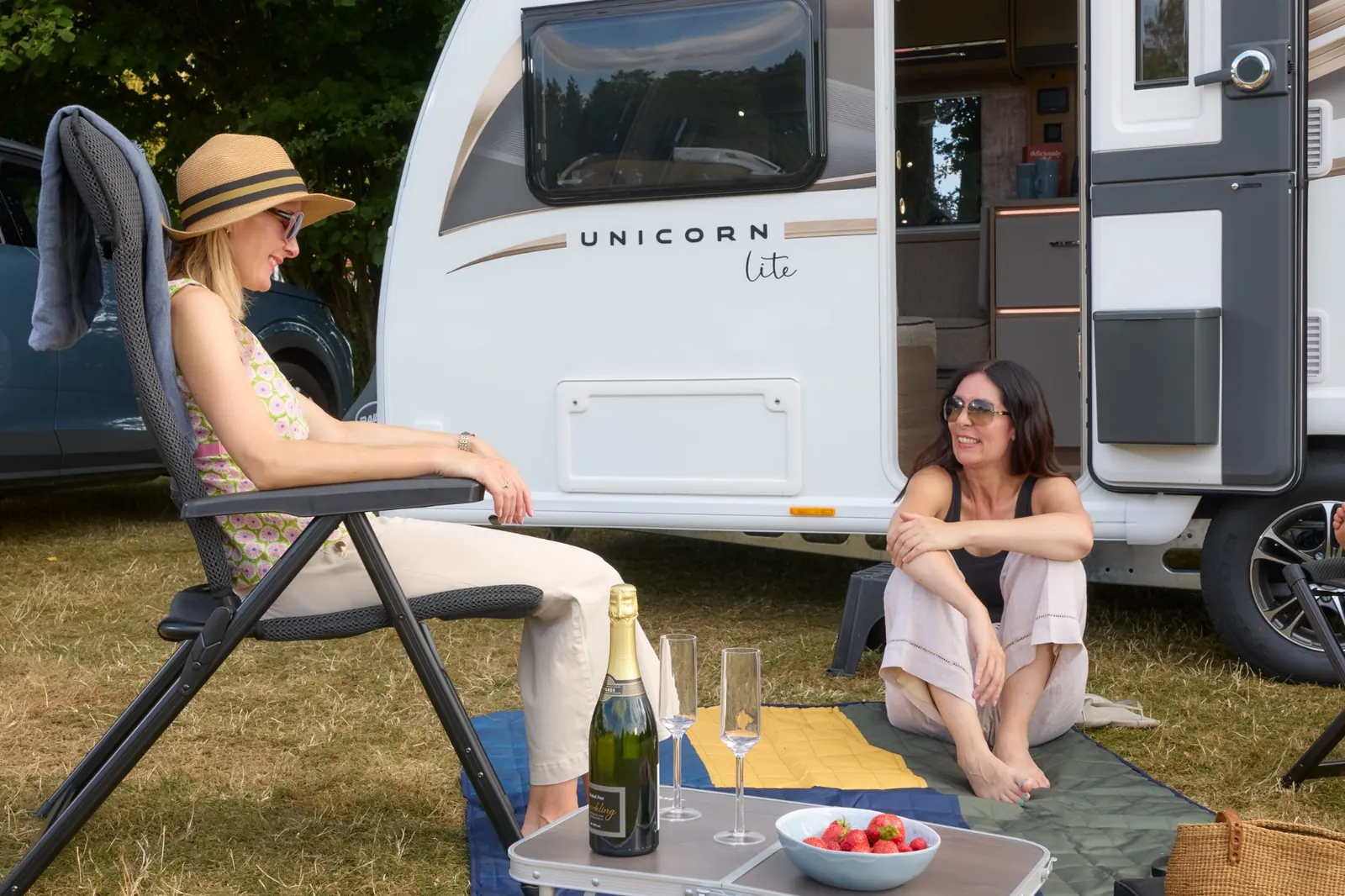 Friends enjoying time together outside a Bailey Unicorn Lite caravan